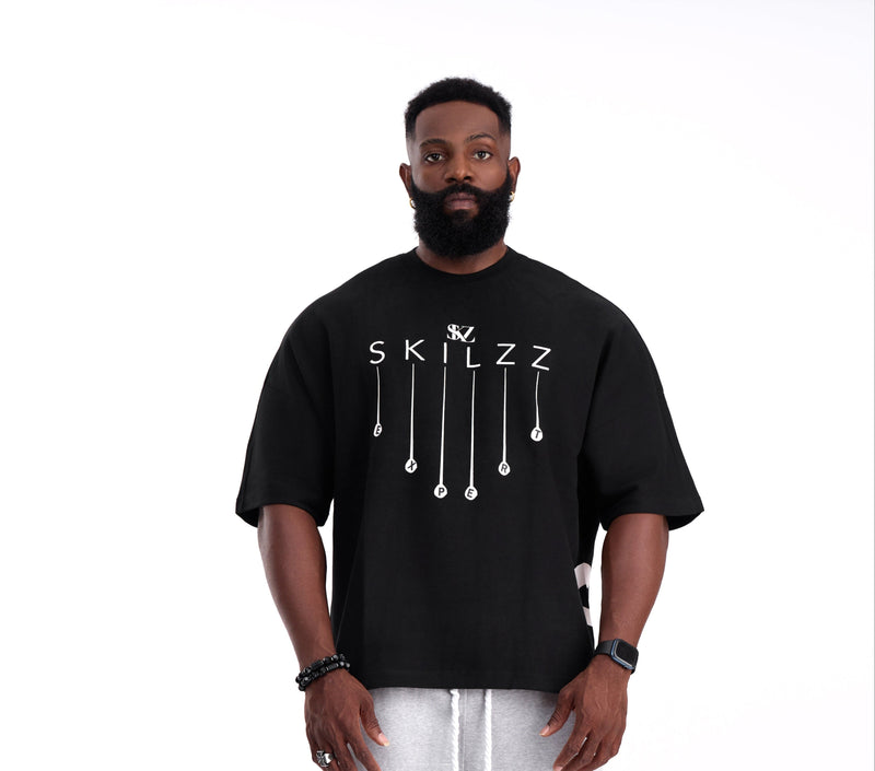 Man wearing a black t-shirt with 'SKILZZ' design on a white background