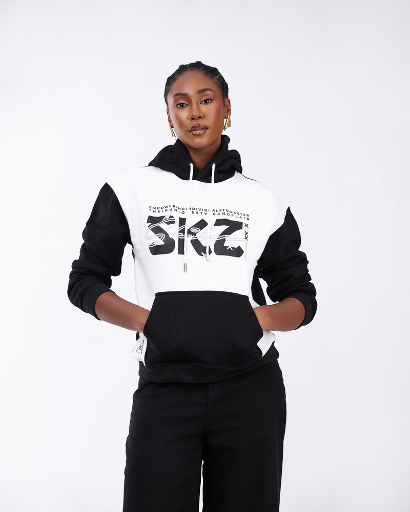 Person wearing a black and white hoodie with 'SKZ' branding on a white background