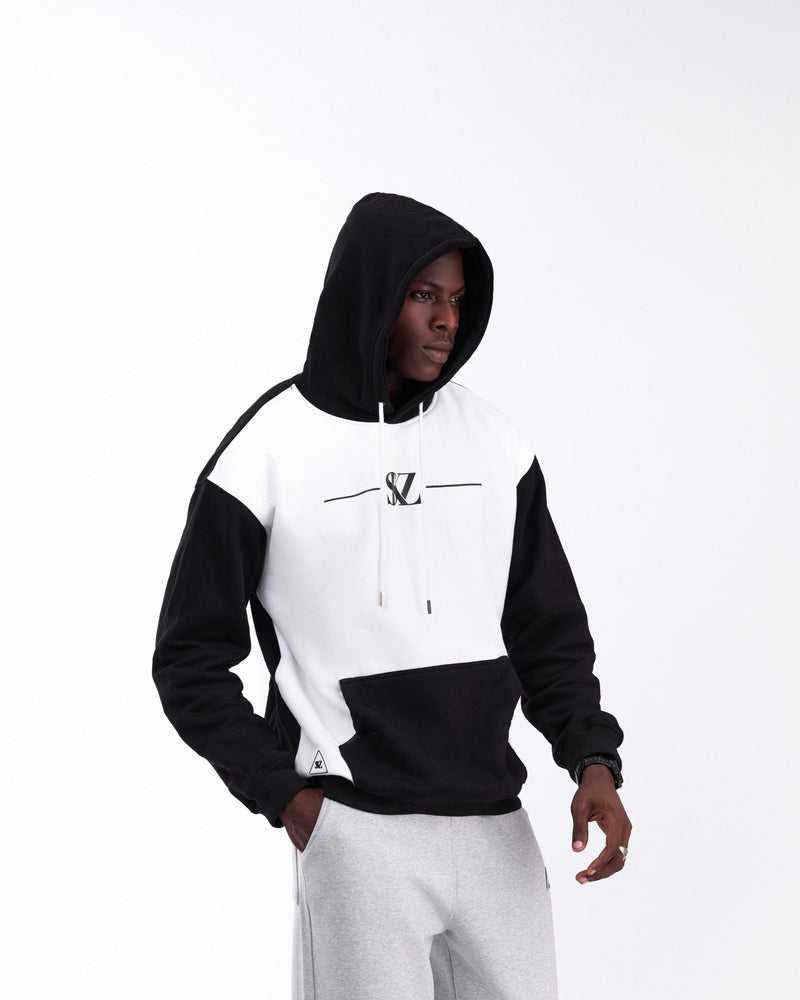 Person wearing a black and white hoodie with a SKZ logo on a white background